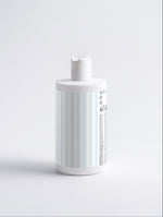 A cylindrical pump bottle with a white cap and a pale light-blue label, shown from a side angle on a clean white background.